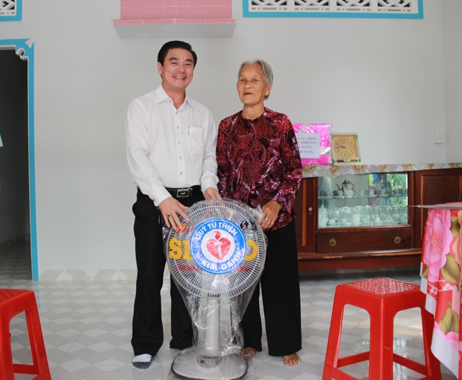 Ông Nguyễn Thuận, Chủ tịch Hội đồng quản trị Công ty cổ phần Địa ốc Kim Oanh, kiêm Chủ tịch danh dự Quỹ từ thiện Kim Oanh trao quà chúc mừng mẹ Phăng về nhà mới 